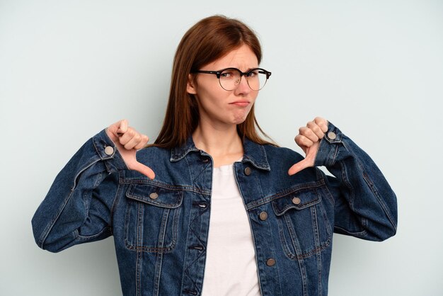 Young English woman isolated on blue background showing thumb down, disappointment concept.