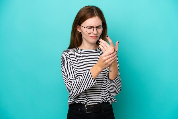 Photo young english woman isolated on blue background suffering from pain in hands