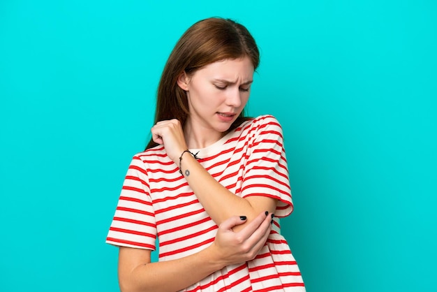 Young English woman isolated on blue background with pain in elbow