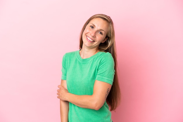 Young English woman isolated on pink background laughing