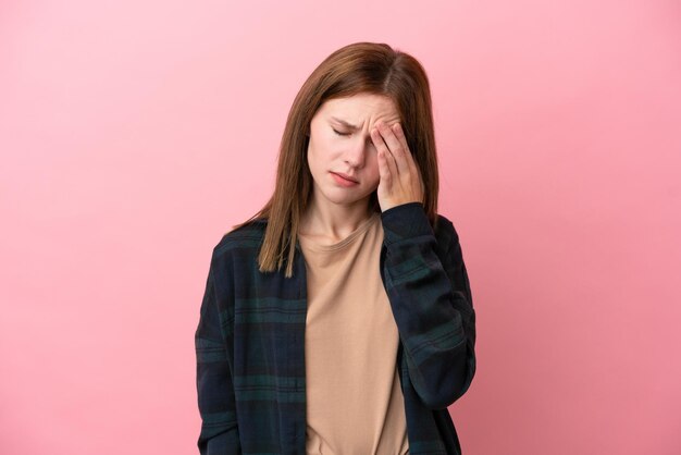 Young English woman isolated on pink background with headache