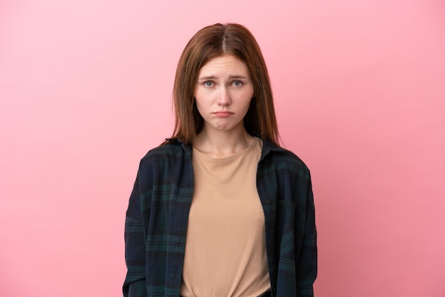 Young English woman isolated on pink background with sad expression