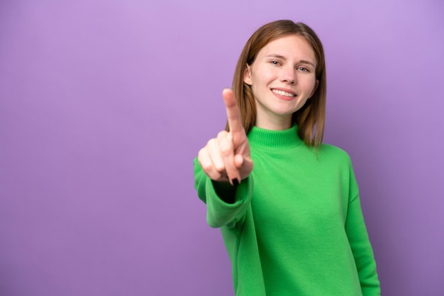 Young English woman isolated on purple background showing and lifting a finger