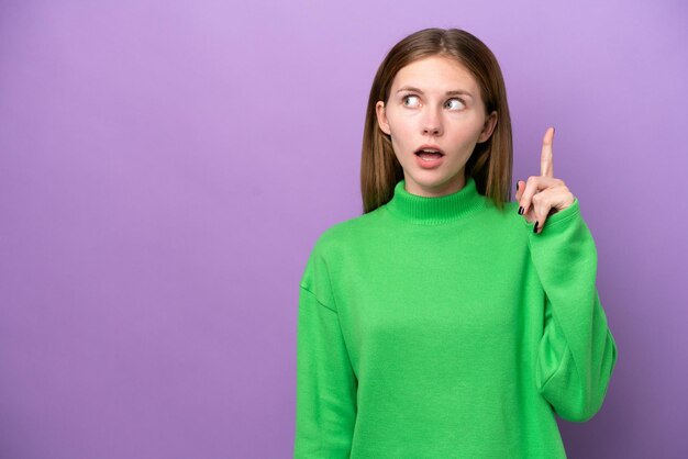 Young English woman isolated on purple background thinking an idea pointing the finger up