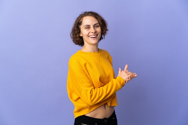 Young English woman isolated on purple space applauding