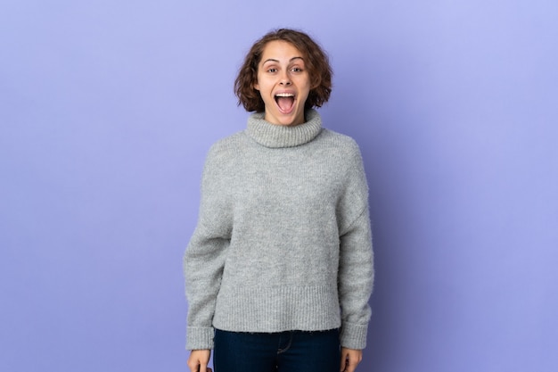 Young English woman isolated on purple wall with surprise facial expression