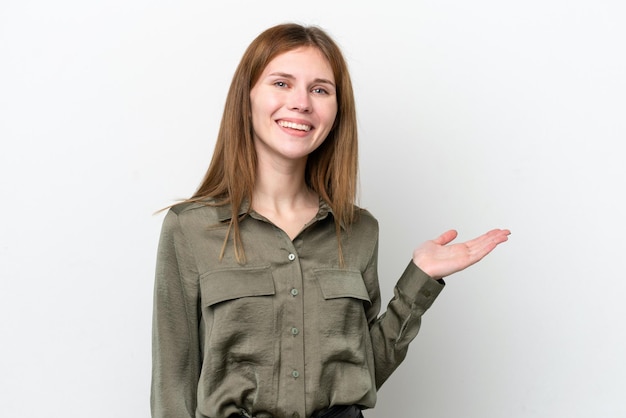 Young English woman isolated on white background holding copyspace imaginary on the palm to insert an ad