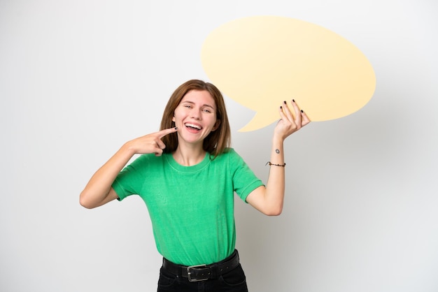 Young English woman isolated on white background holding an empty speech bubble and pointing it