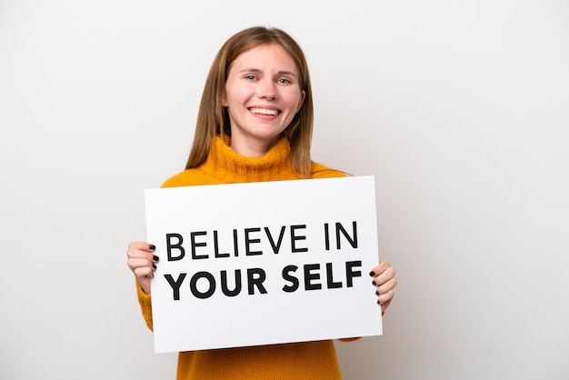 Young English woman isolated on white background holding a placard with text Believe In Your Self with happy expression