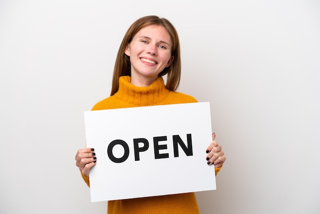 Young English woman isolated on white background holding a placard with text OPEN with happy expression