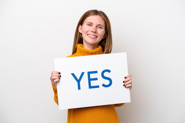 Young English woman isolated on white background holding a placard with text YES with happy expression