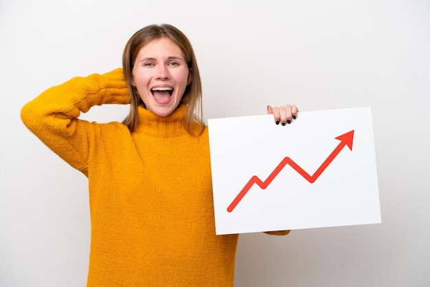 Young English woman isolated on white background holding a sign with a growing statistics arrow symbol with surprised expression