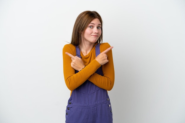 Young English woman isolated on white background pointing to the laterals having doubts