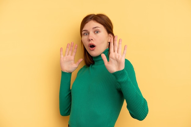 Foto giovane donna inglese isolata su sfondo giallo scioccata a causa di un pericolo imminente