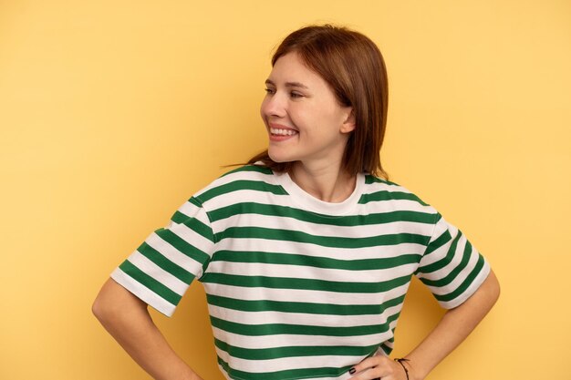 Young English woman isolated on yellow background laughs happily and has fun keeping hands on stomach