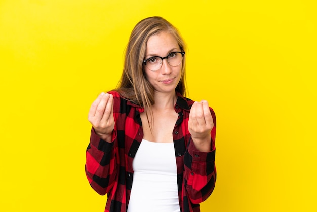 お金のジェスチャーを作る黄色の背景に孤立しているが台無しにされている若いイギリス人女性