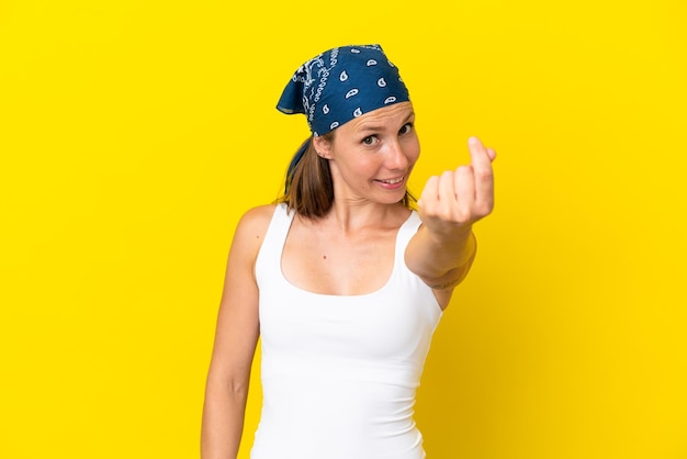 Young English woman isolated on yellow background making money gesture