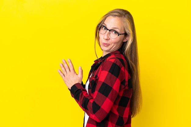 Young english woman isolated on yellow background scheming something