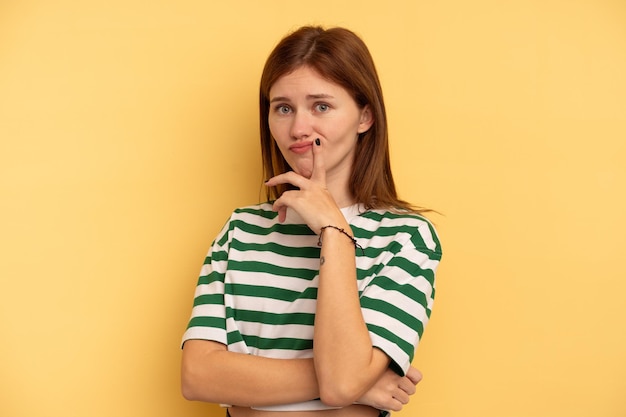 Young English woman isolated on yellow background unhappy looking in camera with sarcastic expression.