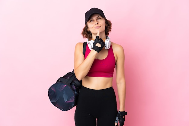 Young English woman on pink having doubts while looking up