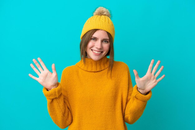 Young English woman wearing winter jacket isolated on blue background counting ten with fingers