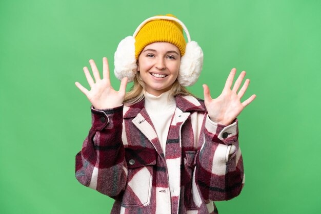 Foto giovane donna inglese che indossa manicotti invernali su sfondo isolato contando dieci con le dita