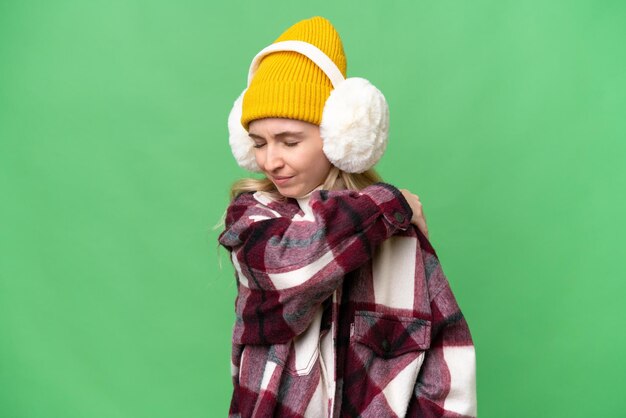 Young English woman wearing winter muffs over isolated background suffering from pain in shoulder for having made an effort