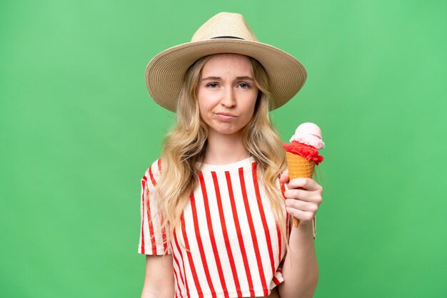 Young English woman with a cornet ice cream over isolated background with sad expression