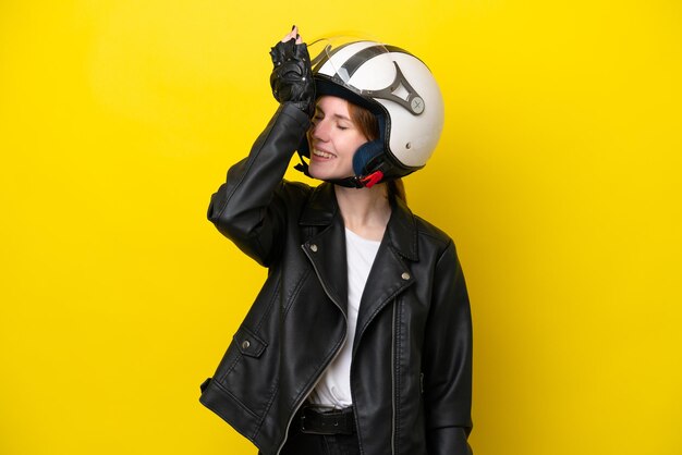 Young english woman with a motorcycle helmet isolated on yellow\
background has realized something and intending the solution