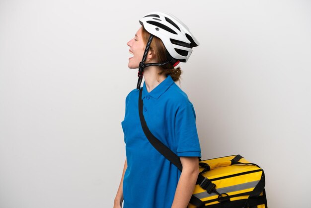 Young English woman with thermal backpack isolated on white background laughing in lateral position