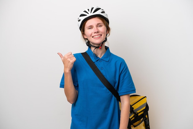 Young English woman with thermal backpack isolated on white background pointing to the side to present a product