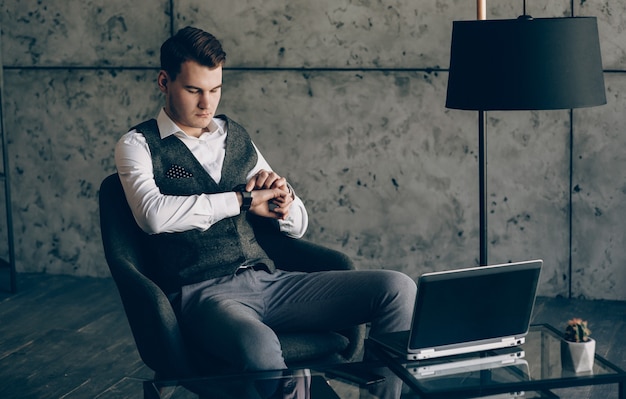 Young entrepreneur looking at his watch