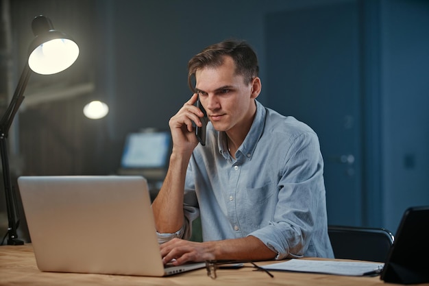 Young entrepreneur making a night call from his office