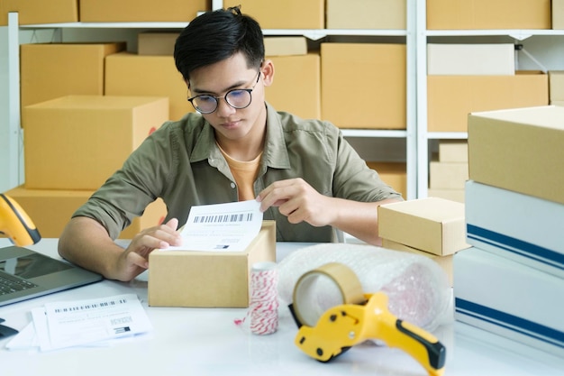 Young entrepreneur packing online order product for shipping