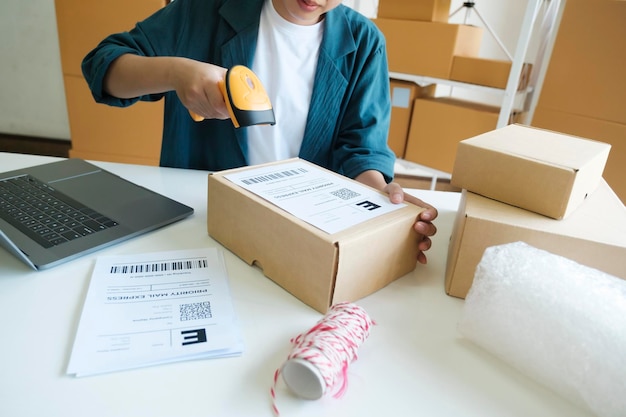 Молодой предприниматель сканирует коробку онлайн-заказа