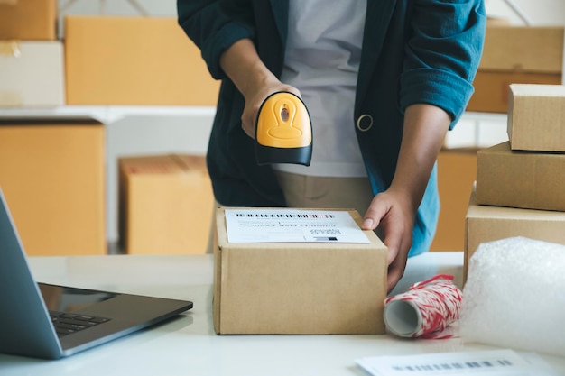 Young entrepreneur scanning online order box