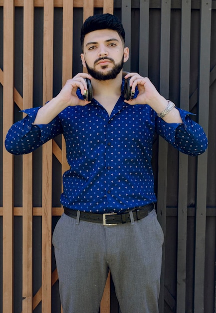 Young entrepreneur standing holding earphones on neck