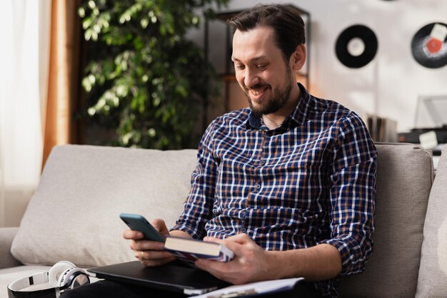 Foto un giovane imprenditore con la barba segue un corso di lingua online sul suo smartphone