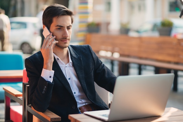 Young entrepreneur working on laptop and phone