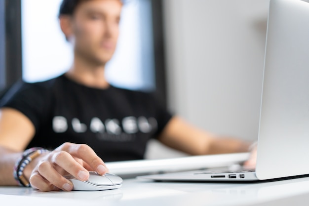 Young entrepreneur works from home in his office with the computer in front of a window