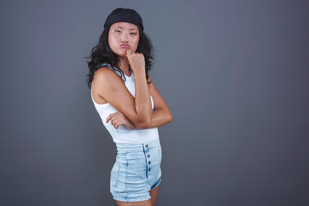 Молодая этническая азиатка в городской одежде вызывающе настроена