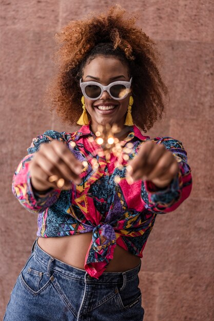 Young ethnic female having fun with sparklers