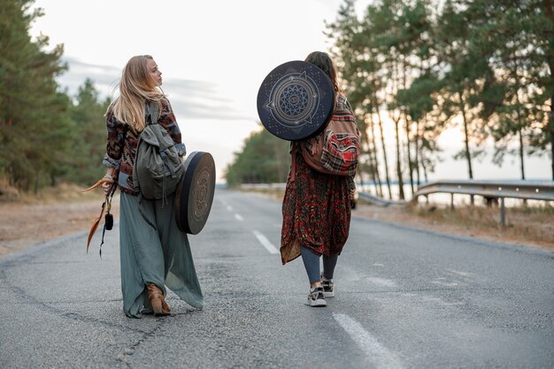 Young ethnic mature shaman female is walking and playing drums meditative music