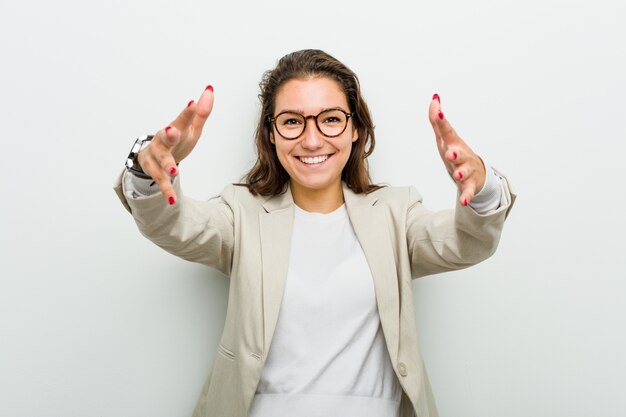 Young european business woman feels confident giving a hug to the camera