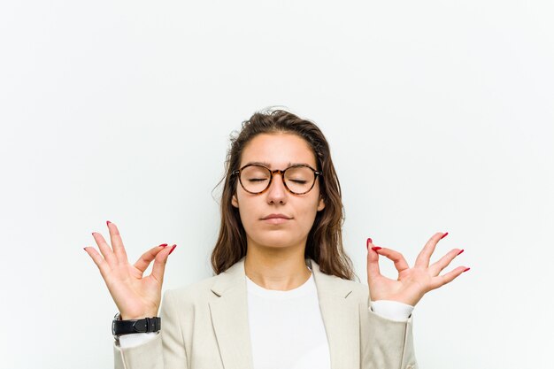 Foto la giovane donna d'affari europea si rilassa dopo una dura giornata di lavoro, sta eseguendo yoga.