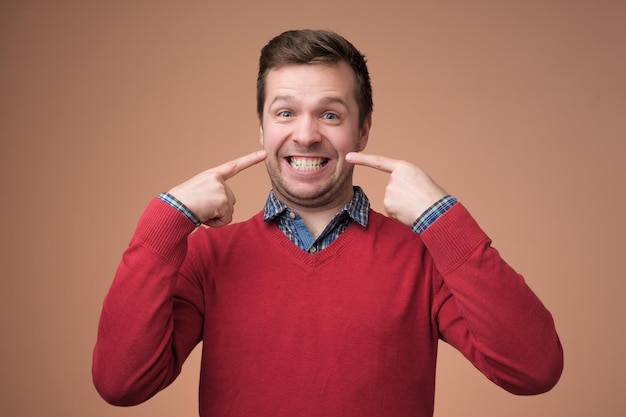 Young european man shows on his teeth