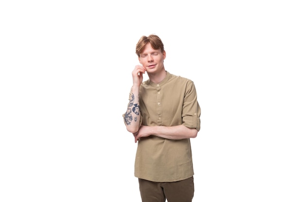Young european man with red golden hair is dressed in a light brown shirt on a white background