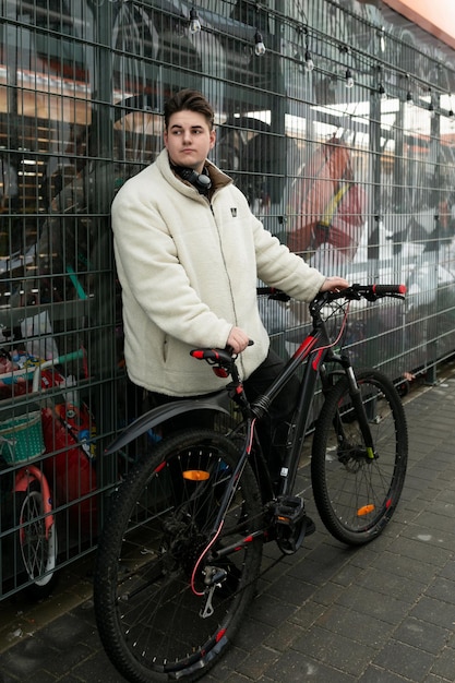 A young european man with a winter jacket took his bike outside