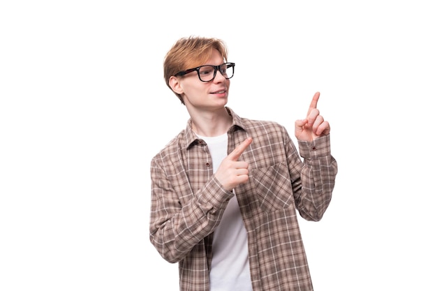 Young european promoter man with golden hair in glasses and a shirt gesturing on a white background