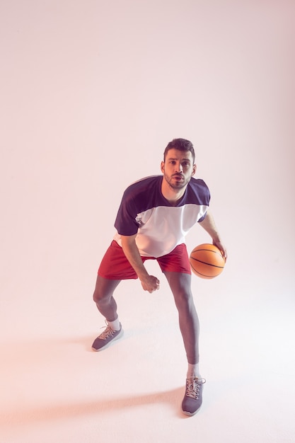 写真 若いヨーロッパのスポーツマンはスタジオでバスケットボールをします